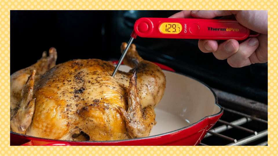 يدويًا باستخدام مقياس حرارة المطبخ الأحمر Thermopro للتحقق من تبرمة الدجاج