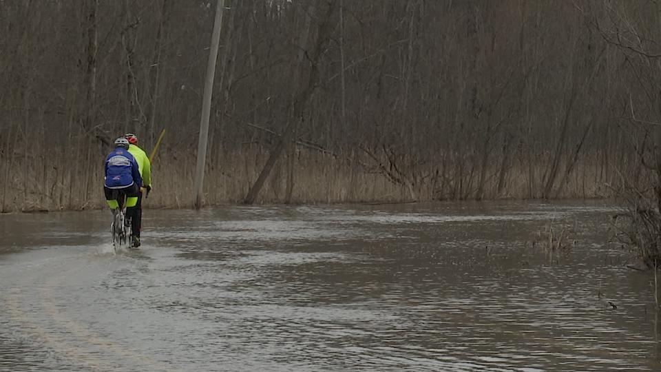 يركب السائقون جنبا إلى جنب على شارع بحيرة ريد الذي غمرته المياه بعد العواصف. (1 أبريل 2025)