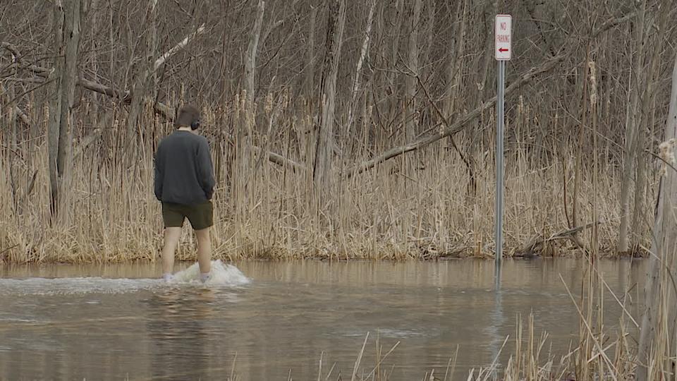 يمشي أحد المشاة في شارع ليك ريد الذي غمرته المياه بعد العواصف. (1 أبريل 2025)