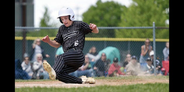 Blooming Prairie’s Eliot Gimbel slides into home against Spring Grove during a Section 1A Tournament Saturday afternoon at Riverland Community College. Eric Johnson/photodesk@austindailyherald.com