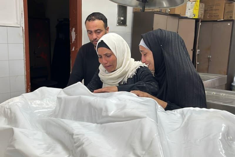 أقارب الفلسطينيين الذين فقدوا حياتهم بعد أن قصف الجيش الإسرائيلي العديد من المنازل في غزة ، يتم نقل جثث الفلسطينيين الذين فقدوا حياتهم في الهجوم إلى مستشفى الشيفا في مدينة غزة. Hadi Daoud/APA صور عبر Zuma Press Wire/DPA