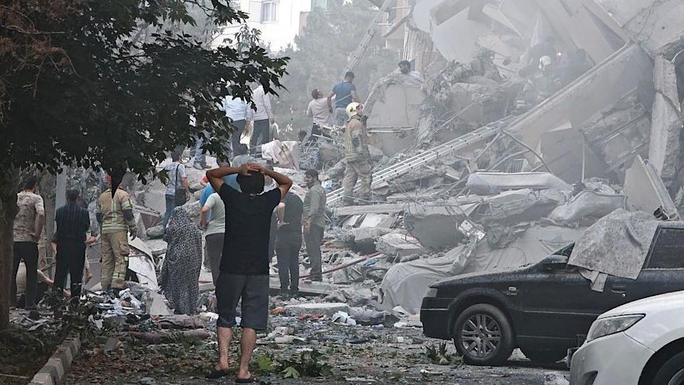 ينظر الناس إلى أضرار للمباني في ميدان نوبونياد بعد ضربات الجوية الإسرائيلية في 13 يونيو 2025 في طهران ، إيران