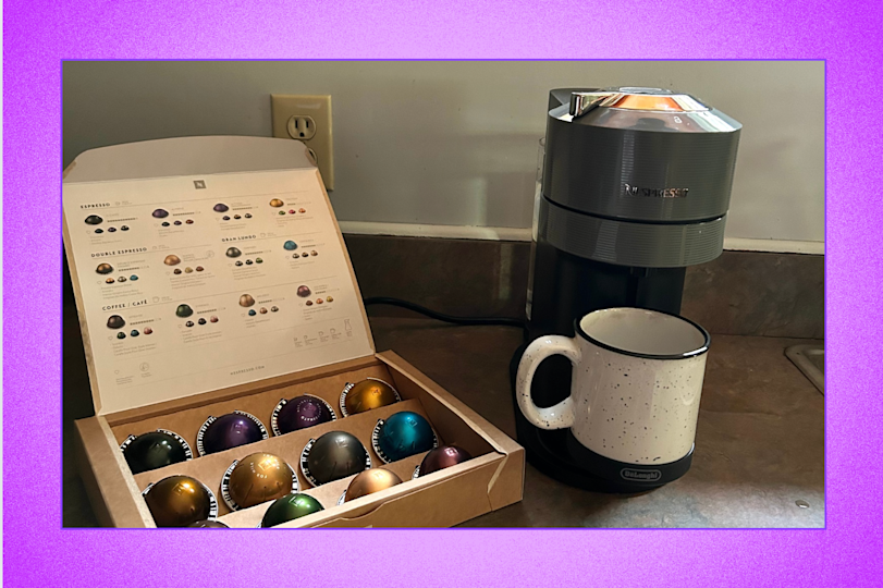 مربع من الورق المقوى من قرون Nespresso بجوار الجهاز التالي في Vertuo