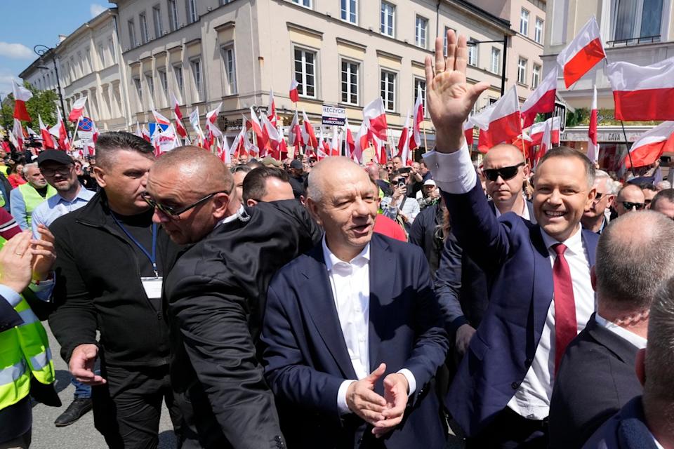 كارول نوروكي ، إلى اليمين ، الأمواج أثناء مشاركته في مسيرة قبل أسبوع واحد من الانتخابات الحاسمة في وارسو بولندا يوم الأحد (AP)
