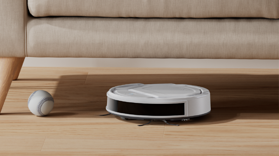فراغ Roomba Robot تحت أريكة ، بجانب لعبة البيسبول