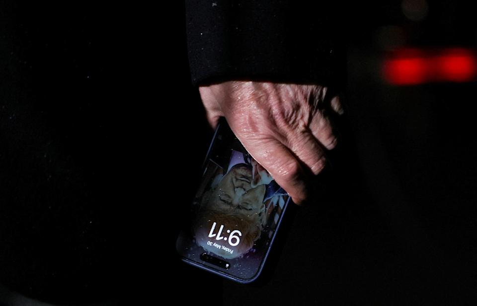 يمكن رؤية شاشة قفل ترامب وهو يحمل جهاز iPhone الخاص به