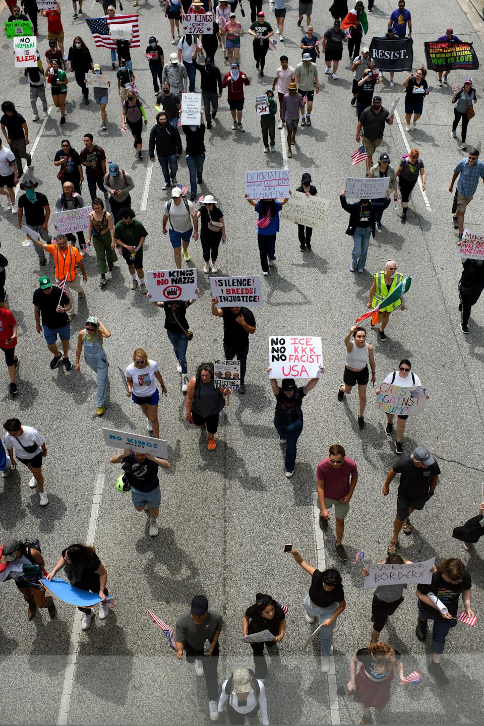 الصورة: الناس يسيرون ويحملون علامات وأعلام احتجاج. (Mark Felix / AFP عبر Getty Images)
