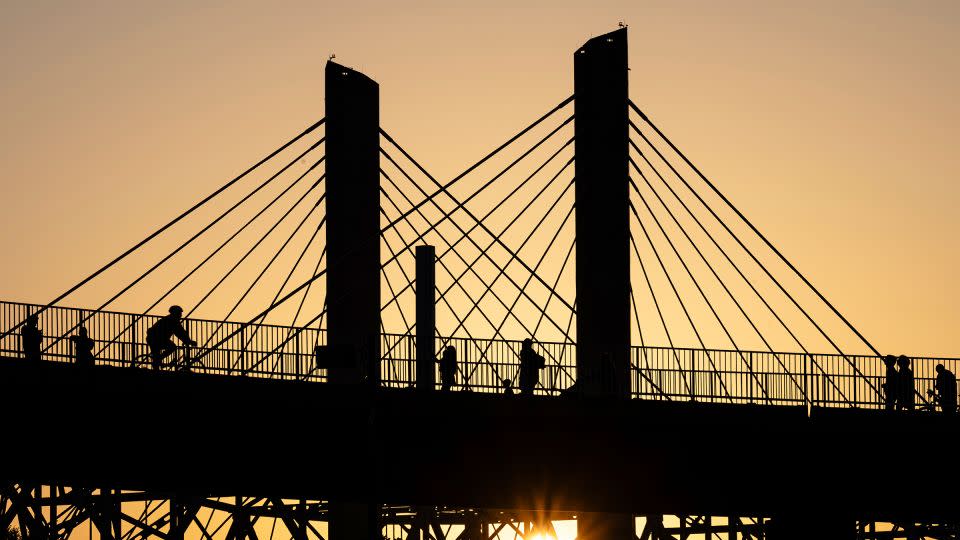 يمشي Poeple عبر جسر Big Four بينما تغرب الشمس في Waterfront Park في 22 يونيو في لويزفيل ، كنتاكي. - جون شيري/أب