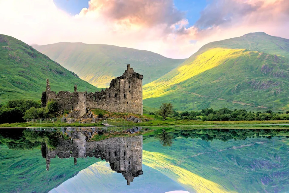 قلعة Kilchurn الجميلة على Loch Awe في المرتفعات في اسكتلندا عند غروب الشمس مع انعكاسات. الصورة الائتمان: Jenifoto / Shutterstock