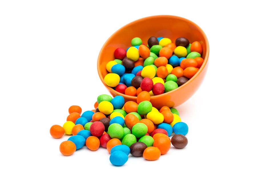 وعاء من الفول السوداني M & MS ، مع بعض الانسكاب على طاولة.