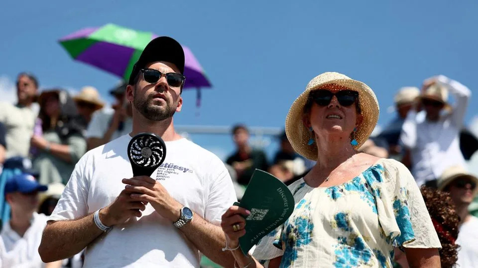 يستخدم المتفرجون في Wimbledon التنس المشجعين المحمولين لتبريد أنفسهم خلال المباراة الأولى بين دانييل ميدفيديف الروسي وبنيامين بونزي في لندن ، في 30 يونيو 2025. - إيزابيل إنفانتس/رويترز