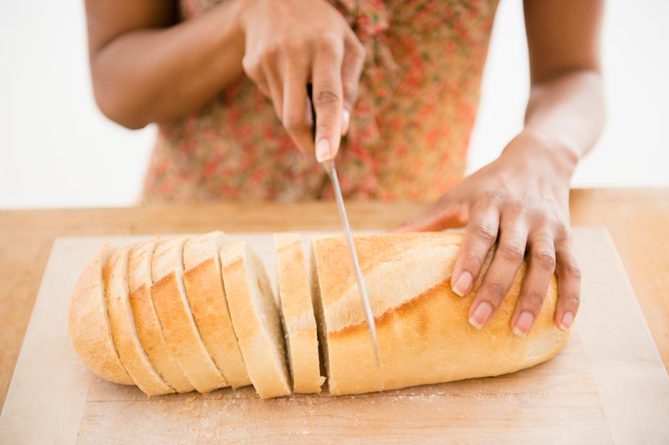 امرأة تقطع رغيف الخبز.