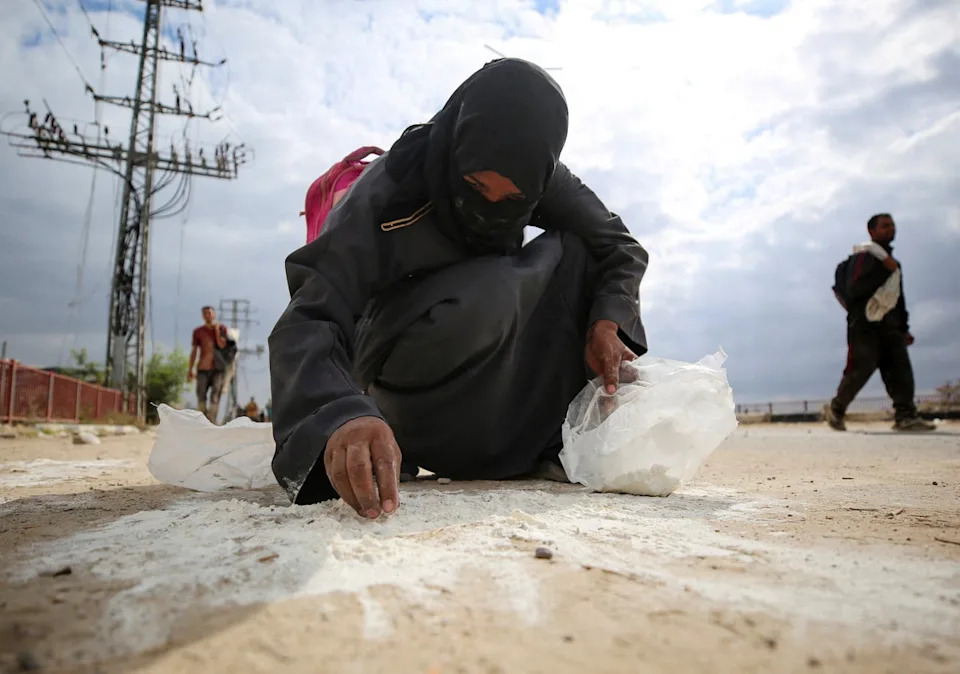 تجمع امرأة الدقيق من الأرض حيث يتلقى الفلسطينيون إمدادات المساعدات من مؤسسة غزة الإنسانية المدعومة من الولايات المتحدة (رويترز) (رويترز)