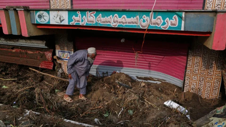 يقوم صاحب متجر بإزالة الطين والحطام أمام متجره بعد فيضان يوم الجمعة في سوق في بير بابا ، وهي منطقة في منطقة بونر ، باكستان ، في 17 أغسطس 2025. - محمد سجاد/أ.