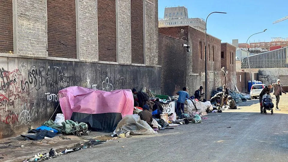 هناك صف من الخيام والمساكن المؤقتة يكمن على جانب الطريق.