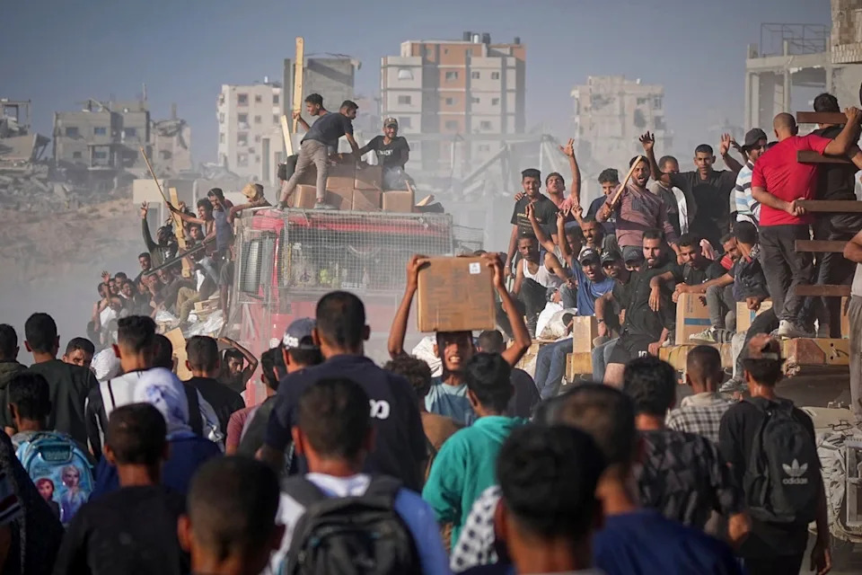 الفلسطينيون على شاحنة طعام في غزة (AP)