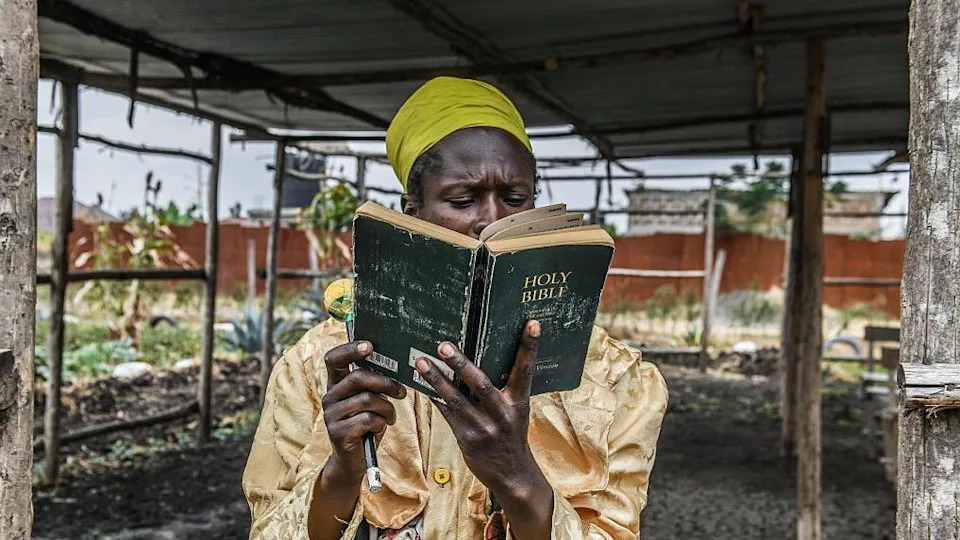 رجل يقرأ الكتاب المقدس الأسود تحت سقف في نيروبي ، كينيا - الأحد 24 أغسطس 2025.