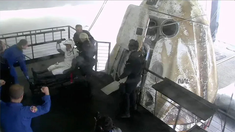 تقوم Crew 10 Commander Anne McClain بحماس بقبضاتها في الهواء للاحتفال بنهاية مهمة ناجحة مدتها خمسة أشهر إلى محطة الفضاء الدولية. / الائتمان: SpaceX