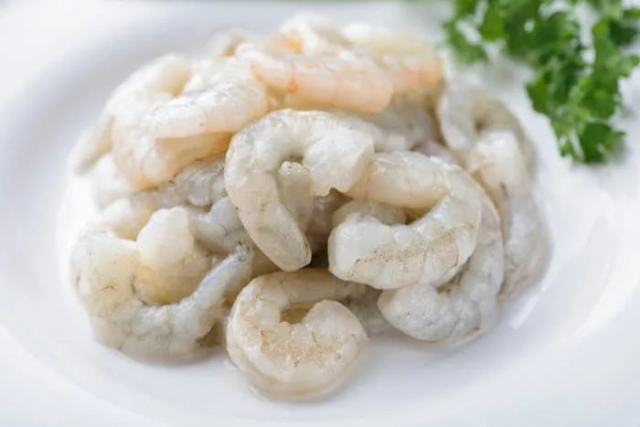 طبق من الروبيان غير المطبوخ مع غصن من البقدونس للزينة