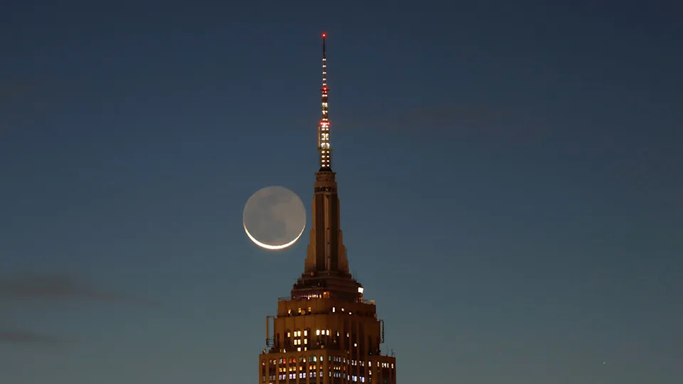 يظهر القمر الهلال بجوار مبنى Empire State.