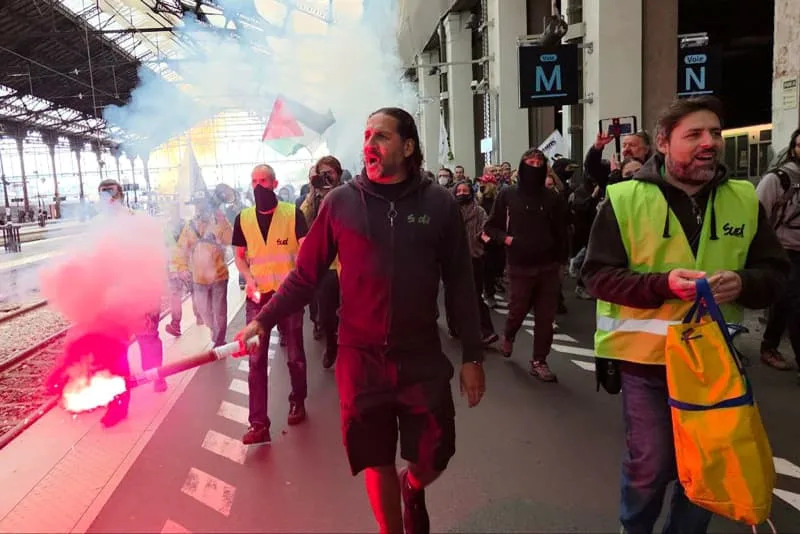 يحمل الناس مشاعلًا أثناء احتجاجهم على Gare de Lyon مطالبين باستقالة رئيس فرنسا إيمانويل ماكرون. Dmitry Orlov/Tass عبر Zuma Press/DPA