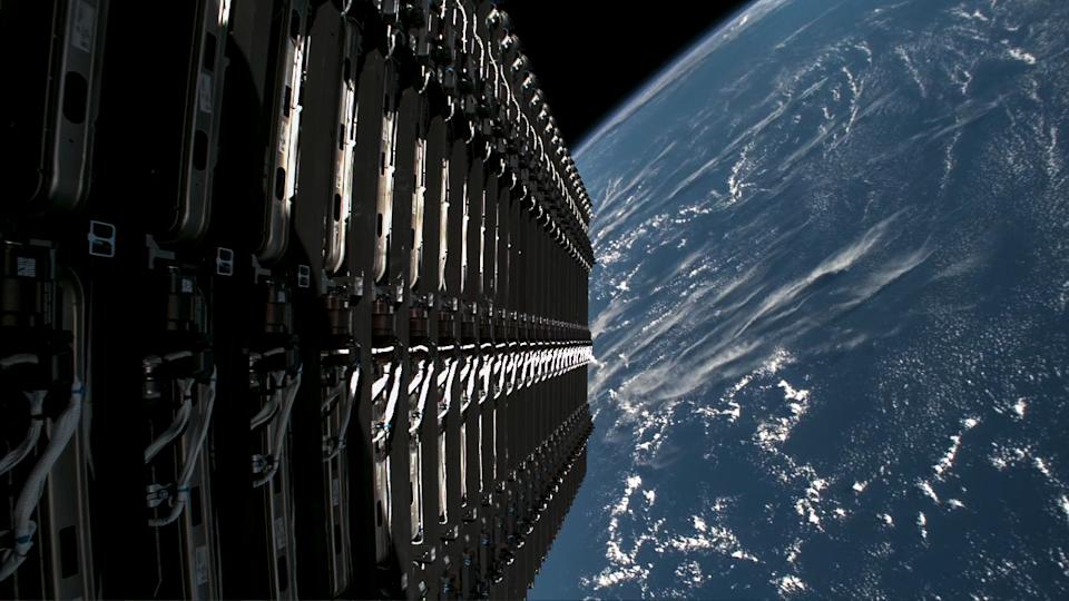 عرض من المرحلة العليا قبالة صاروخ Falcon 9 ، يوضح كومة من 28 من الأقمار الصناعية مع الأرض في الخلفية
