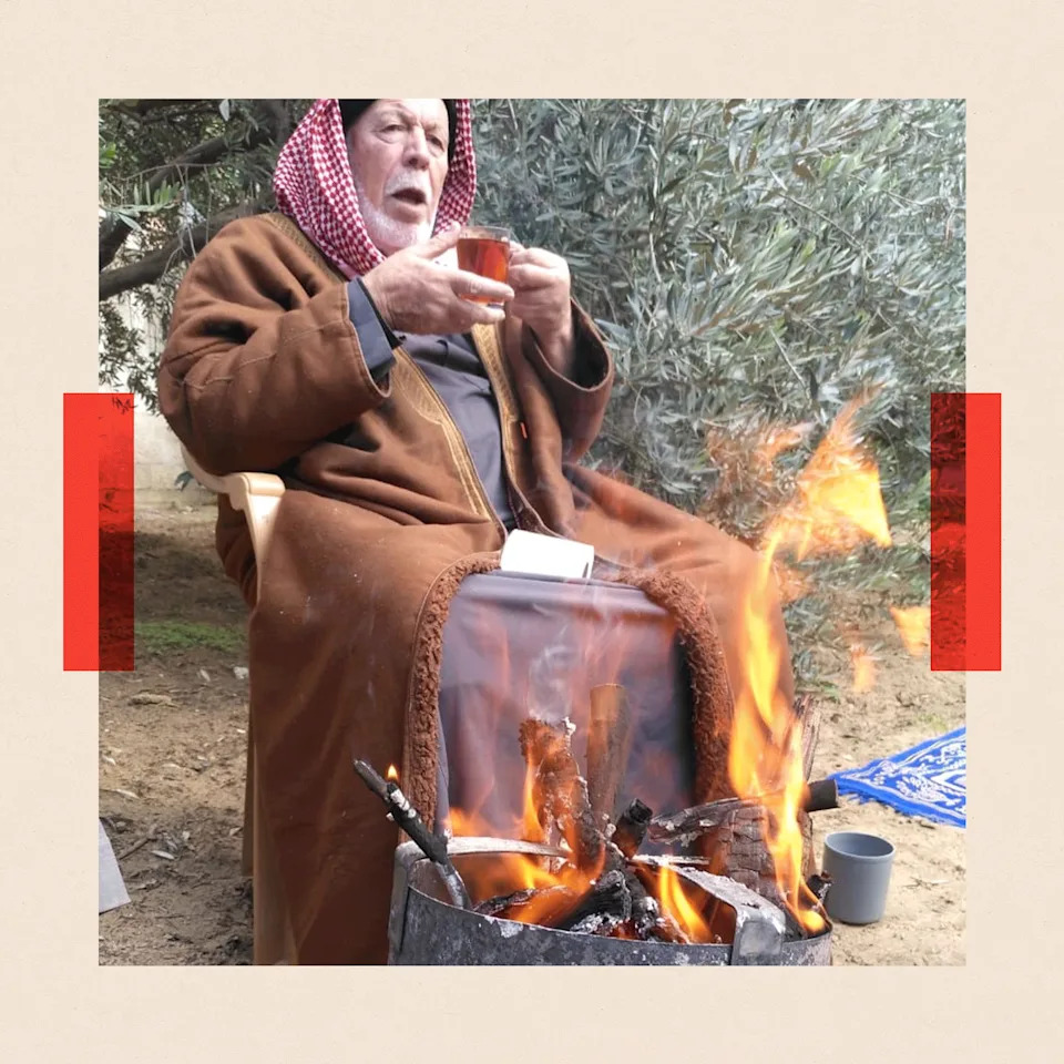 عايش يجلس بجانب النار
