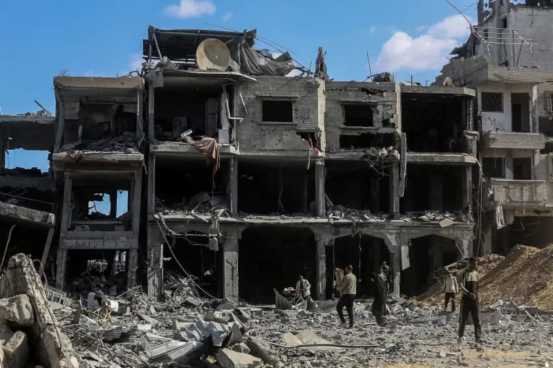 أشخاص يتفقدون مبنى مدمر أثناء عودة النازحين الفلسطينيين إلى منازلهم بعد انسحاب الجيش الإسرائيلي من بعض المناطق شرق خان يونس جنوب قطاع غزة، عقب الإعلان عن اتفاق بين إسرائيل وحركة حماس الفلسطينية بشأن تنفيذ المرحلة الأولى من خطة السلام الأمريكية لقطاع غزة. عبد الرحيم الخطيب/ د ب أ