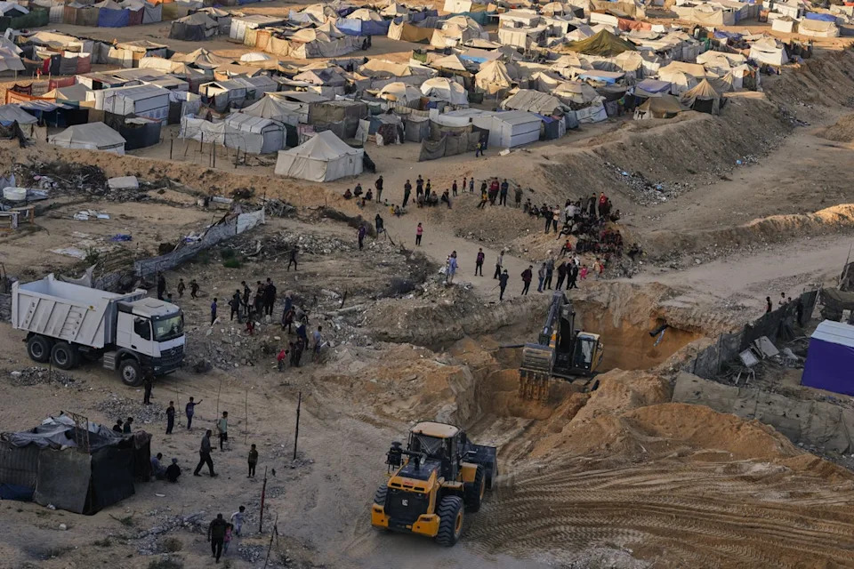 فلسطينيون يعملون على انتشال جثث الرهائن في غزة يوم الاثنين (أ ف ب)