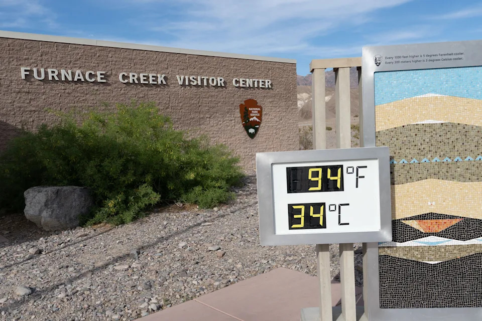 تظهر شاشة درجة الحرارة في مركز زوار Furnace Creek 94 درجة فهرنهايت (34 درجة مئوية) في المناظر الطبيعية الصحراوية