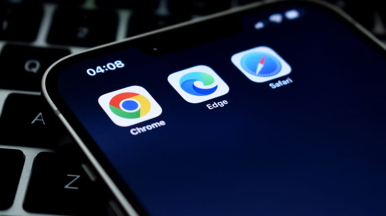 جهاز iPhone يعرض أيقونات تطبيقات متصفح Chrome وEdge وSafari.