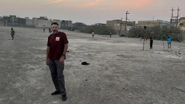 صورة بن سوبيت مع أطفال يلعبون كرة القدم في موقع مقبرة الحرب