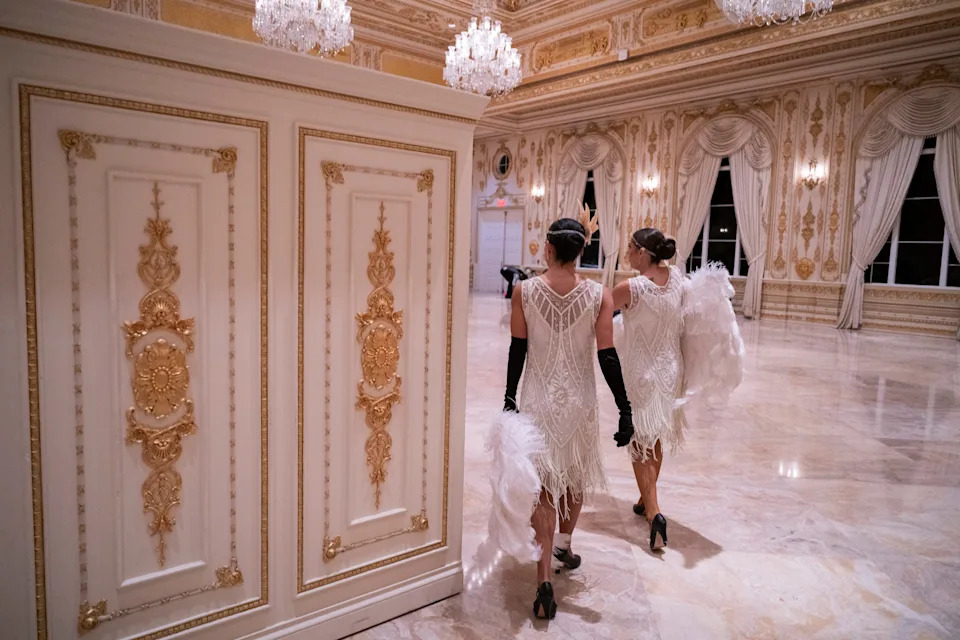 راقصون يسيرون في قاعة المناسبات في مارالاغو خلال حفل الهالوين الذي يحمل طابع ترامب غاتسبي. / روبرتو شميدت / وكالة الصحافة الفرنسية عبر Getty Images