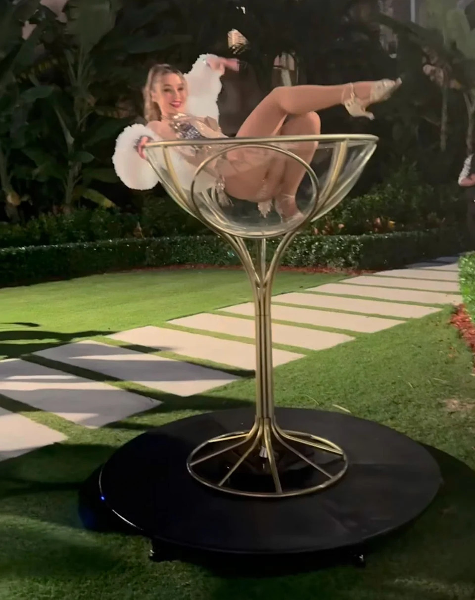 امرأة تتظاهر بكأس مارتيني عملاق في حفلة مار لاغو للهالوين. / لا يوجد