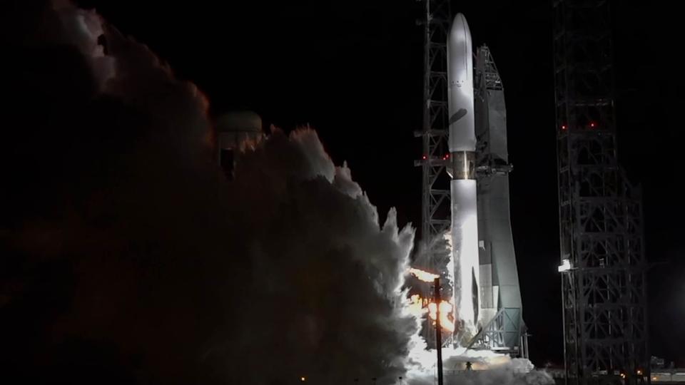 صاروخ أبيض طويل ينفث الدخان من الأسفل بينما تشتعل محركاته.