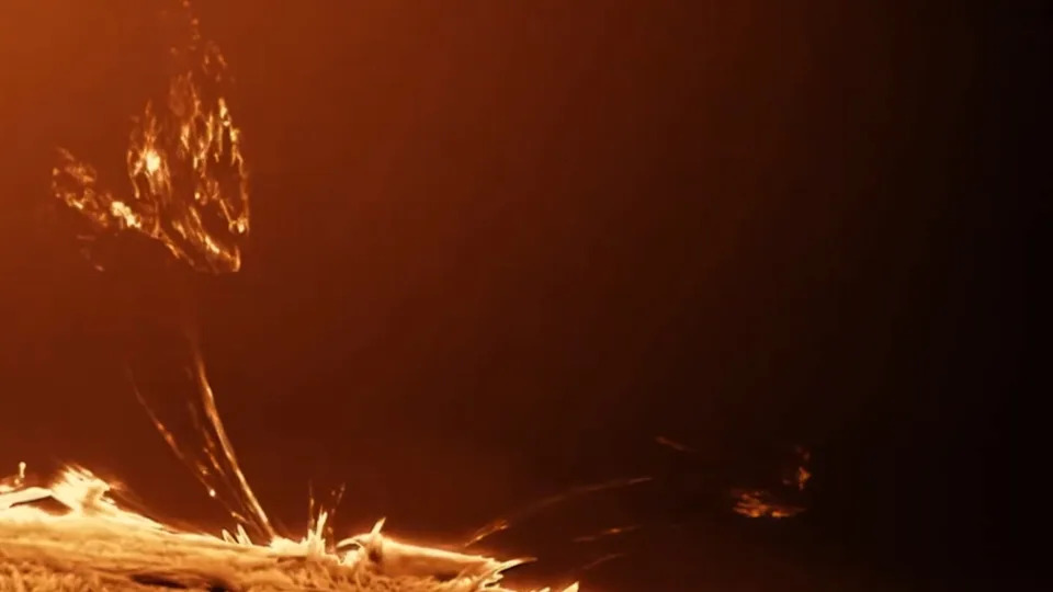 منظر قريب للشمس مع محلاق ناري يمتد من السطح إلى الفضاء ويعود للأسفل. يبدو سطح الشمس غامضًا وناعمًا، كما لو كنت ترغب في لمسه - لكن لا ينبغي عليك فعل ذلك.