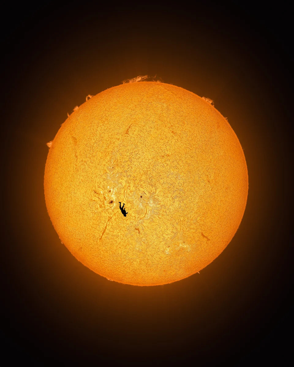 لاعب قفز مظلي يسقط أمام الشمس المغلية.