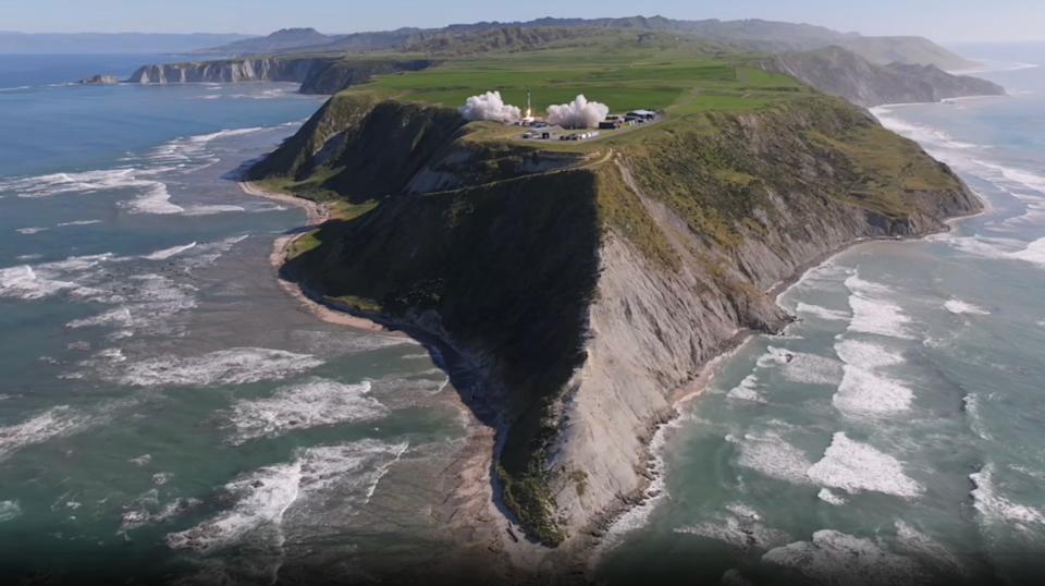 يتشكل عمود من الدخان الرمادي على طرف جزيرة صخرية ترتفع من محيط متموج