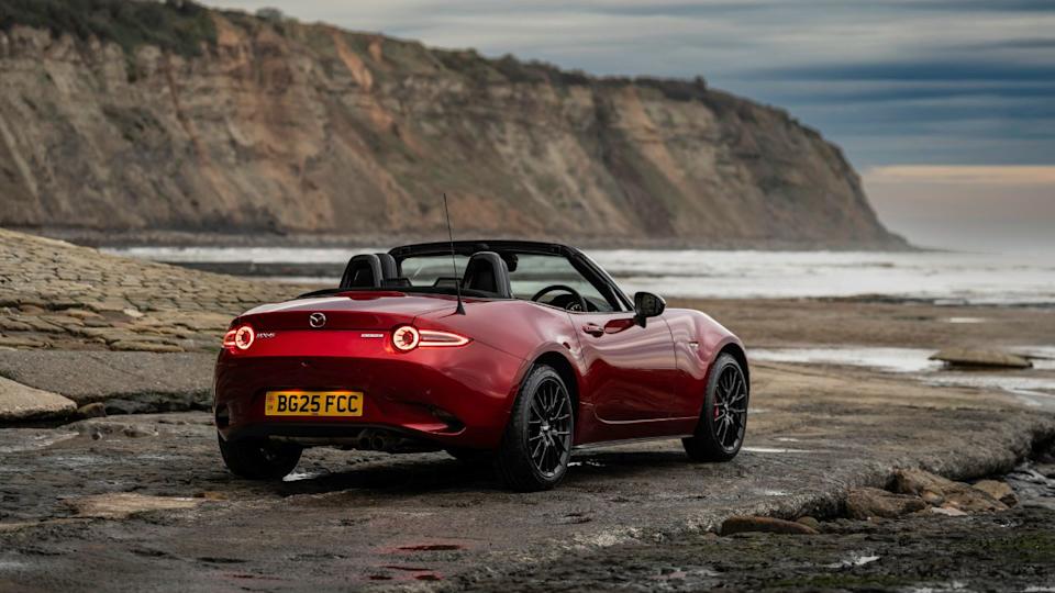 مازدا MX-5 مياتا 2024 باللون الأحمر متوقفة مع عرض سقف خلفي 3/4