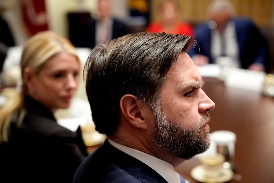 الأفراد في اجتماع رسمي حول طاولة، يظهرون مركزين ومنخرطين في المناقشة