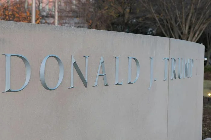 التوقيع مع النص "دونالد جيه ترامب" على سطح حجري منحني كبير في الهواء الطلق