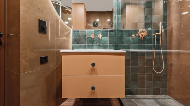 حمام مزود ببلاط باكسبلاش من بلاط الزليج الأزرق وجدران وأرضيات من التراكوتا.