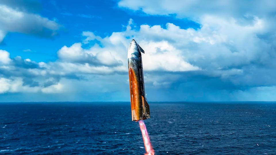 تنزل مركبة فضائية ذات لون برتقالي محمر للهبوط في المحيط تحت سماء زرقاء ملبدة بالغيوم 