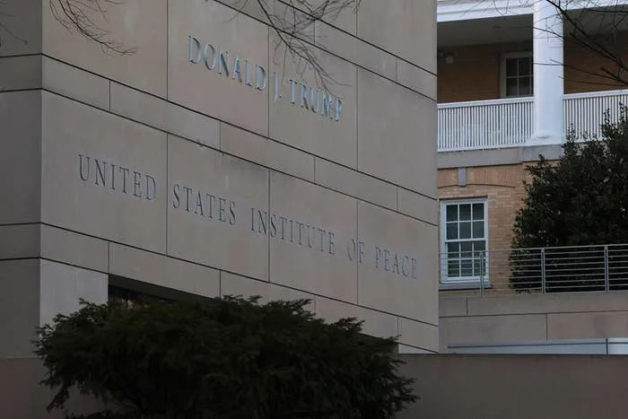 واجهة المبنى مع "معهد الولايات المتحدة للسلام" نص؛ شجرة في المقدمة