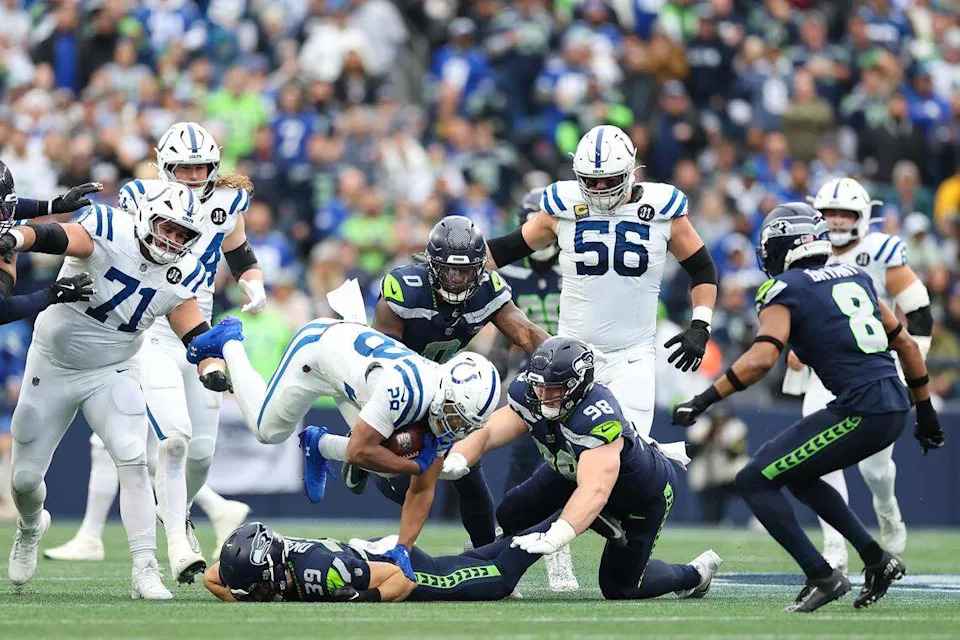 جوناثان تايلور رقم 28 من فريق إنديانابوليس كولتس يحمل الكرة ضد فريق سي هوكس تاي أوكادا رقم 39 ورايلي ميلز رقم 98 خلال الربع الثاني في ملعب لومين فيلد في 14 ديسمبر 2025 في سياتل. كان ميلز يظهر لأول مرة في دوري كرة القدم الأمريكية بعد 12 شهرًا من تعرضه لتمزق في أربطة الركبة وهو يلعب في مباراة كرة القدم الجامعية لصالح نوتردام. (تصوير ستيف تشامبرز / غيتي إيماجز)