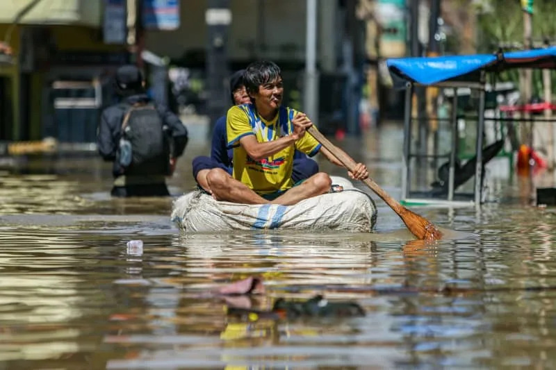 أحد السكان يجدف بقاربه المؤقت وسط مياه الفيضانات في دايوهكولوت. كلاوديو برامانا / زوما بريس واير / وكالة الأنباء الألمانية