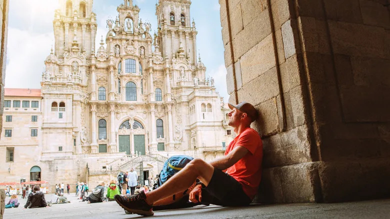 زائر يحمل حقيبة ظهر ويجلس على درجات سلم ساحة أوبرادويرو