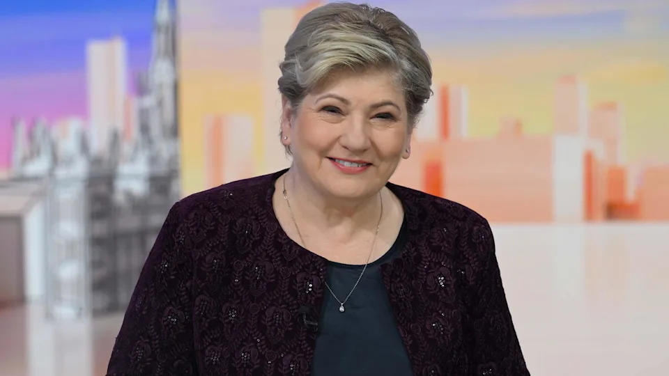 ترتدي النائبة العمالية إميلي ثورنبيري سترة حمراء وقمة داكنة.