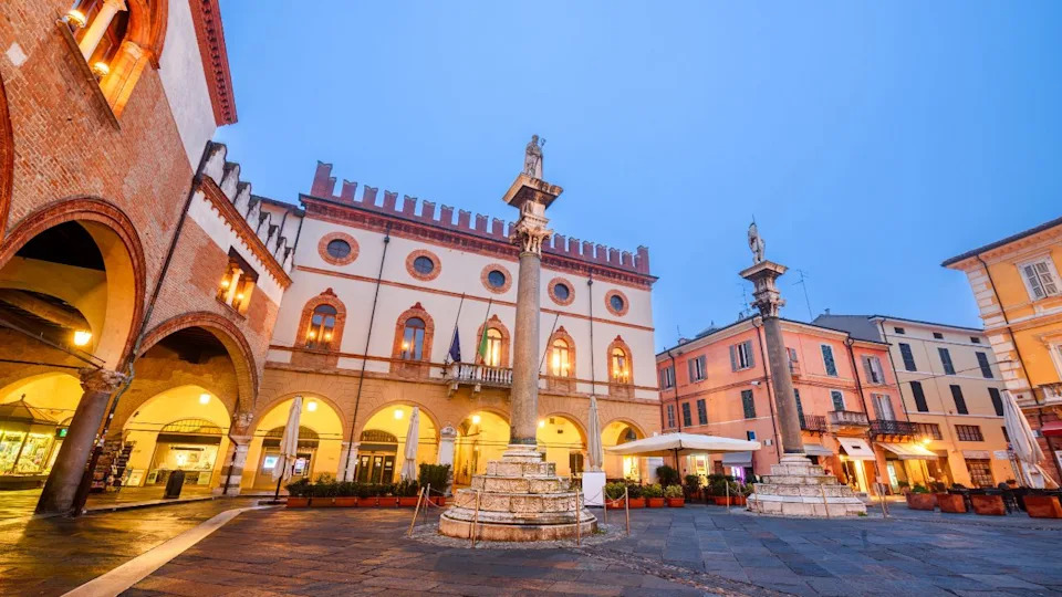 رافينا، إيطاليا في ساحة ديل بوبولو مع أعمدة البندقية التاريخية عند الغسق.