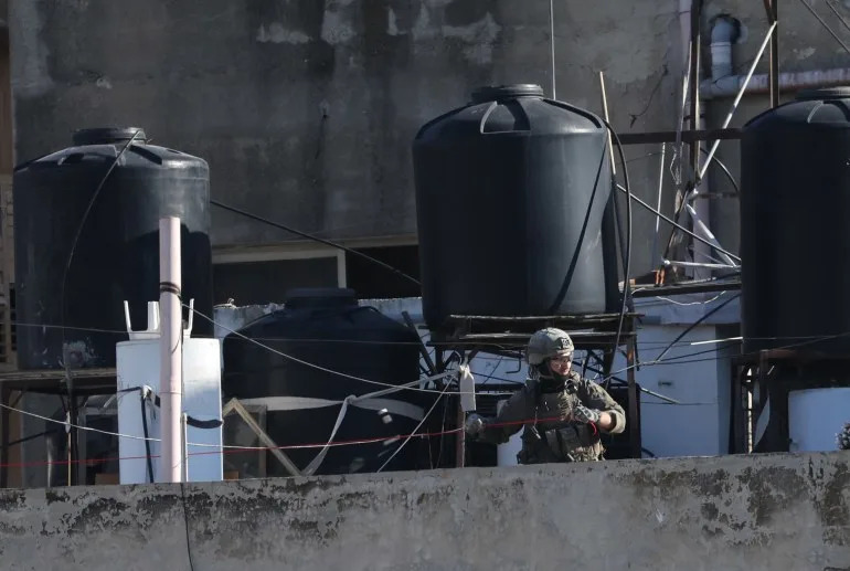 epa12564005 جندي إسرائيلي يجهز عبوات ناسفة لهدم منزل الأسير الفلسطيني عبد الكريم صنوبر في مدينة نابلس بالضفة الغربية، 02 ديسمبر 2025. وبحسب وكالة الأنباء الفلسطينية وفا، هدمت قوات الاحتلال الإسرائيلي شقة الأسير الفلسطيني عبد الكريم صنوبر في قرية زواتا غرب نابلس بالضفة الغربية، بعد مداهمة فجرا. اعتقلت القوات الإسرائيلية صنوبر في 20 فبراير/شباط 2025. EPA/ALAA BADARNEH